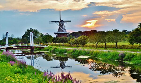 colorful landscape of a waterway bridge and windm 